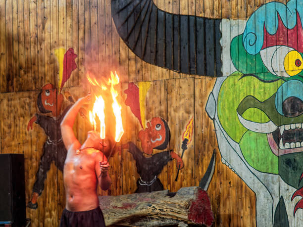 Bare-chested man fire-eating during performance in a tourist park focused on ethnic minorities including Zhuang, Beihai, Guangxi