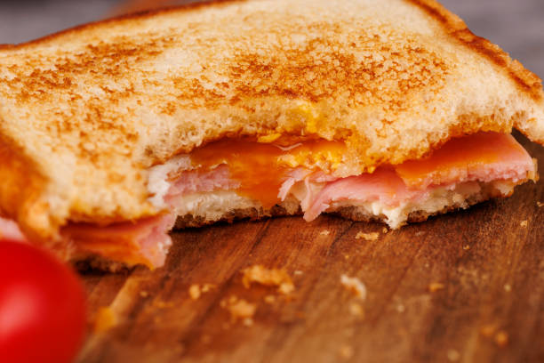 istock Tasty Egg, Ham, and Cheese Sandwich with Cherry Tomatoes on a Gray Concrete Table 2193636394