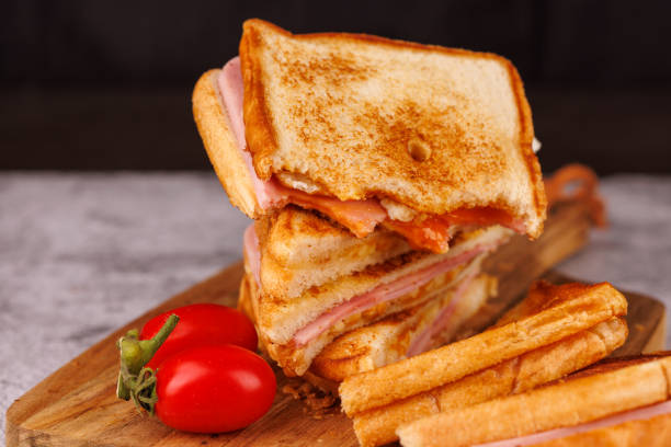 istock Appetizing Egg, Ham, and Cheese Sandwich Partially Eaten with Cherry Tomatoes 2193636421