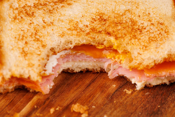 istock Tempting Egg, Ham, and Cheese Sandwich with Cherry Tomatoes on a Dark Board 2193636487