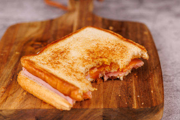 istock Hearty Egg, Ham, and Cheese Sandwich with Cherry Tomatoes on a Gray Table 2193636539