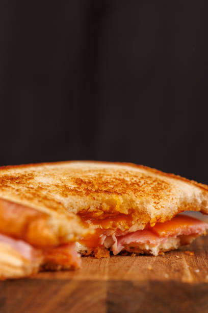 istock Tempting Egg, Ham, and Cheese Sandwich Partially Eaten with Cherry Tomatoes 2193636550