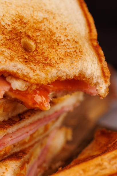 istock Half-Eaten Egg, Ham, and Cheese Sandwich on a Vertical Tower with Cherry Tomatoes 2193636560
