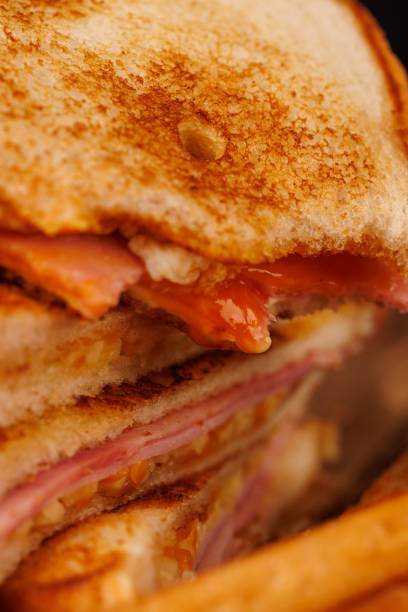 istock Savory Egg, Ham, and Cheese Sandwich with Cherry Tomatoes on a Gray Concrete Table 2193636577