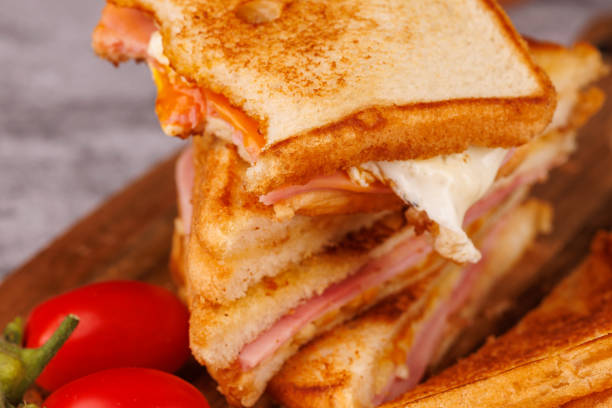 istock Colorful Egg, Ham, and Cheese Sandwich with Cherry Tomatoes on a Gray Concrete Table 2193636588