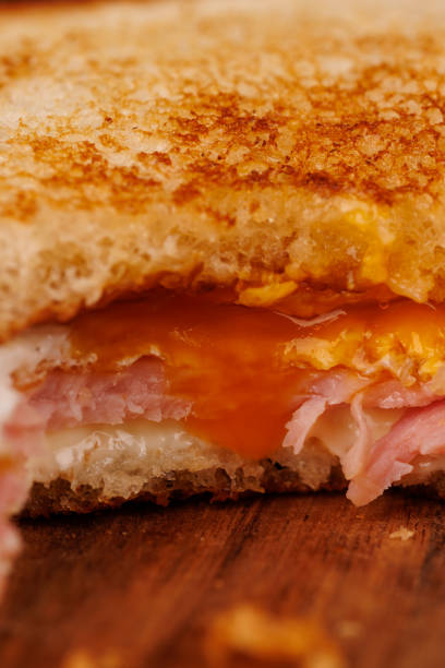 istock Savory Egg, Ham, and Cheese Sandwich Partially Eaten with Cherry Tomatoes 2193636594