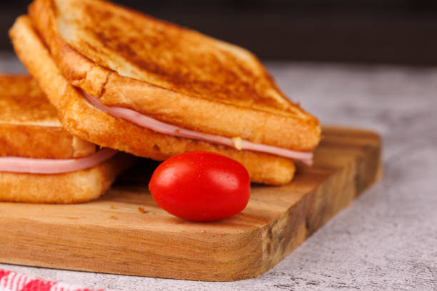 istock Hearty Cheese and Ham Sandwiches with Cherry Tomatoes on a Stylish Concrete Table 2193636605