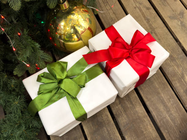 istock Two white and red boxes with green ribbons on them 2193636671