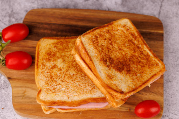istock Savory Cheese and Ham Sandwiches with Cherry Tomatoes on a Black Concrete Table 2193636947