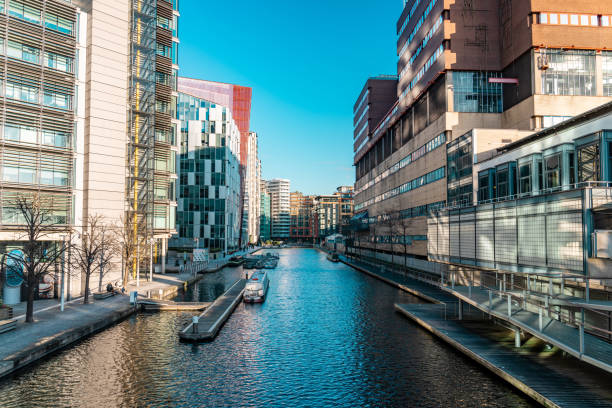 Modern buildings line the paddington basin, a canal in london, uk, creating a vibrant urban scene