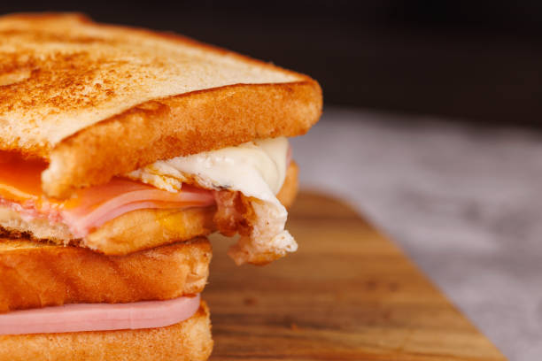 istock Flavorful Cheese and Ham Sandwiches with Cherry Tomatoes on a Dark Table 2193637140