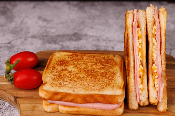 istock Delicious Ham and Cheese Sandwiches Cut in Half on a Concrete Table 2193637310