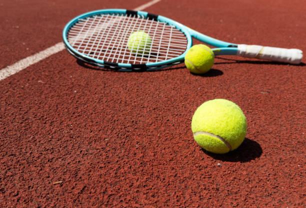 istock Racket with a tennis ball on a red clay court. 2193639617