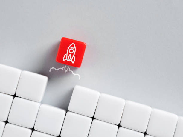 istock Red dice with rocket breaking through white wall of cubes 2193640698