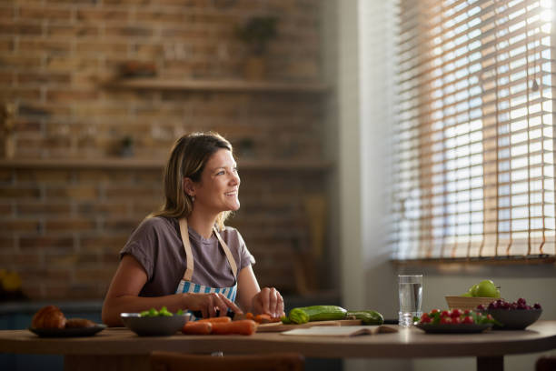 istock Happy female chef cutting carrots in the kitchen. 2193641318