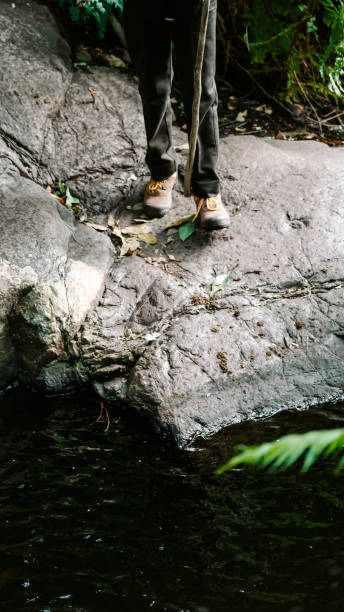 istock Black man standing on a rock next to the river 2193641489