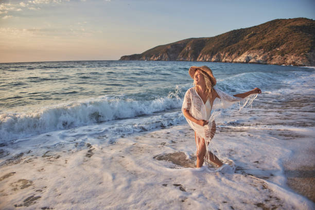 istock Beautiful woman running inside water on the beach at sunset 2193642468