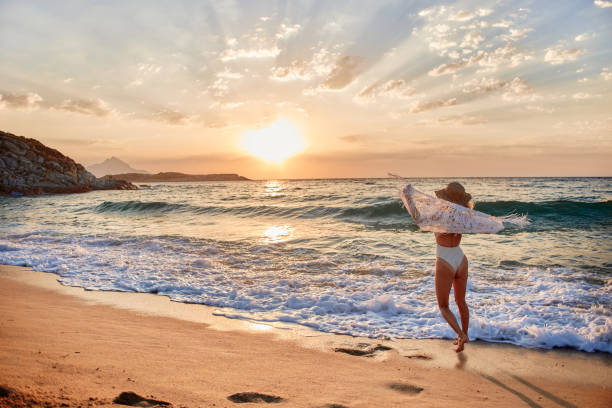 istock Beautiful woman running inside water on the beach at sunset 2193642614