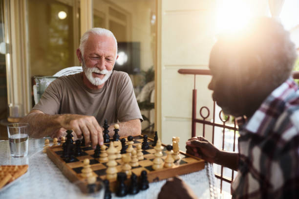 istock Happy senior men playing chess in retirement home. 2193642753