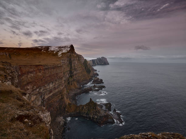 Background of extreme terrain with snow surrounded by sea at Faroe Islands. Photographed in medium format.
