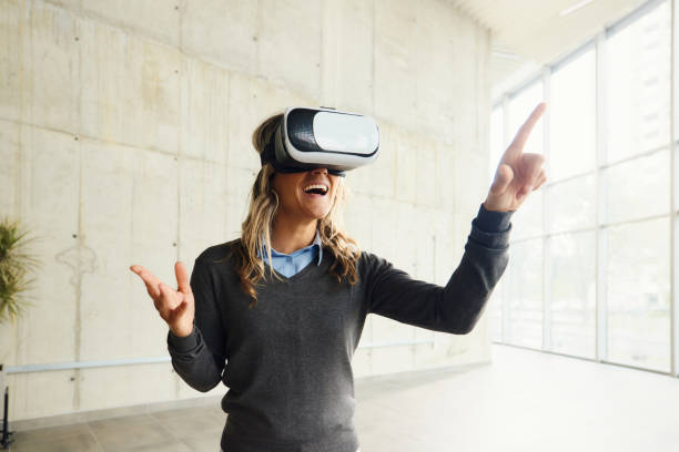istock Happy businesswoman using VR headset in a hallway. 2193645845
