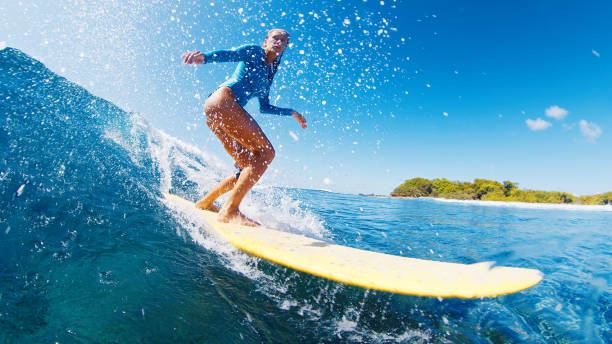 istock Athletic woman surfing waves on yellow surfboard 2193646479