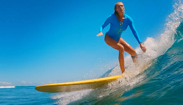 istock Athletic woman surfing waves on yellow surfboard 2193646494