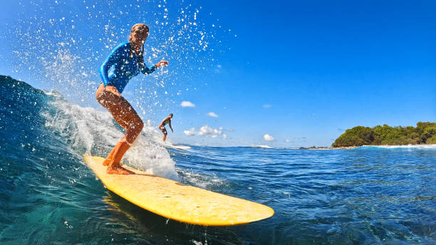 istock Athletic woman surfing waves on yellow surfboard 2193646501