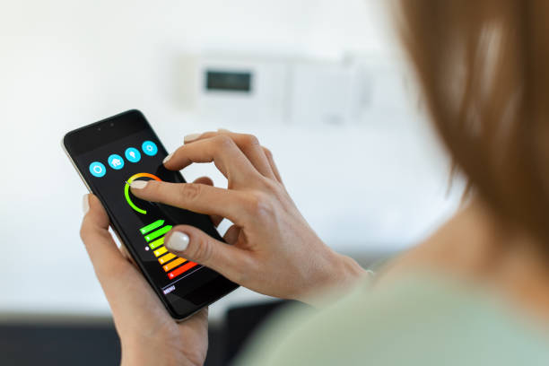 istock Close up of woman's hands controlling home temperature with a smart phone application 2193647413