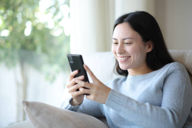 istock Happy asian woman using smart phone at home 2193648037
