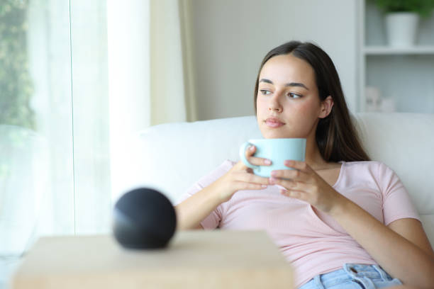 istock Woman relaxing drinking coffee with smart speaker in foreground 2193648039