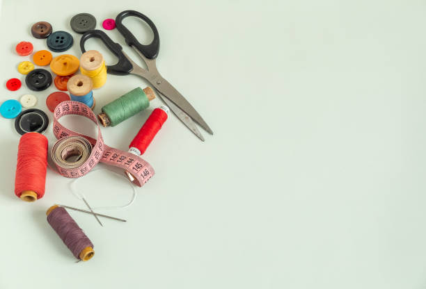 istock Background for sewing. Needlework supplies on a light background. Spools of thread, scissors, buttons, measuring tape, sewing accessories. Needlework kit top view 2193650952