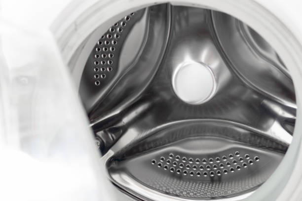 istock Washing machine drum close up. Inside the washing machine. Metal washing machine drum. Perforated shiny metal 2193651155