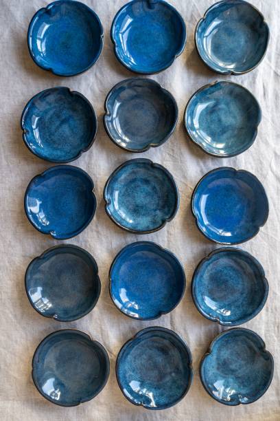 istock Grid of blue ceramic bowls on beige cloth. 2193652531