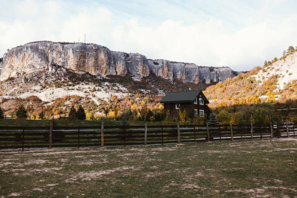 Autumn landscape with a wooden house on the hill in the mountains