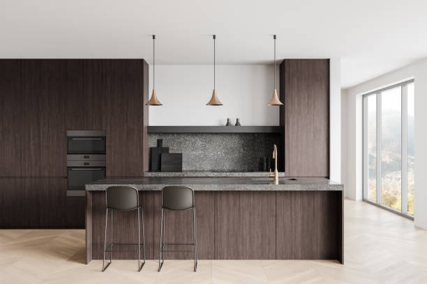 istock Modern kitchen interior with dark wood cabinets, granite countertops, and minimalistic pendant lighting fixtures in a bright, open space. 3D Rendering 2193652925