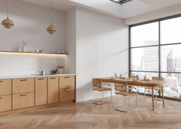 istock Modern kitchen interior with wooden cabinets, dining table, large windows, and city view in a bright room with light wood flooring. 3D Rendering 2193653229