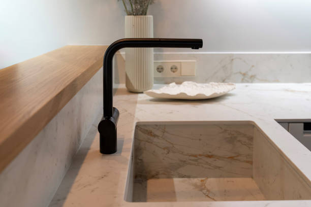 istock Black kitchen tap and marble sink on a light countertop surface 2193653441