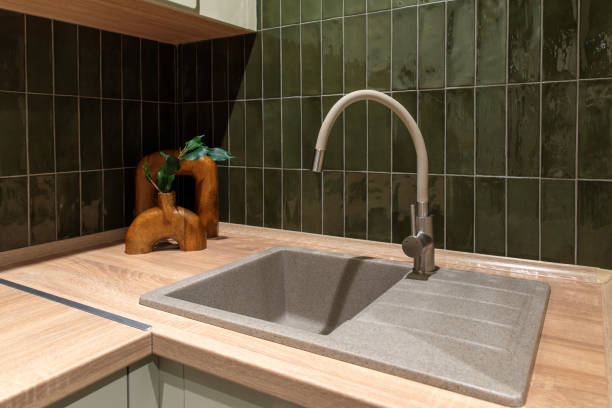 istock Arch kitchen faucet with a granite sink and green tiled backsplash 2193653445