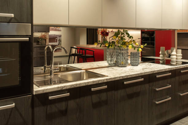 istock Chrome faucet with mirrored backsplash and sink in a kitchen 2193653452