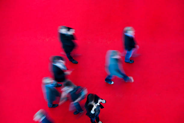 People walking on red carpet, high angle view, blurred motion.