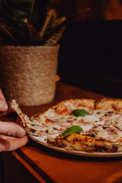 istock Hand Grabbing a Slice of Pizza from a Plate 2193666956