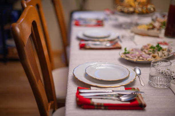 A plate with a patterned design serves as the focal point of this sophisticated table setting. A white napkin, artfully folded and held in place by a golden napkin ring, sits atop the plate. The silverware, featuring intricate handle designs, flanks the plate, suggesting a setting prepared for a formal meal. The softly blurred background contributes to the overall sense of an exclusive and refined dining experience.