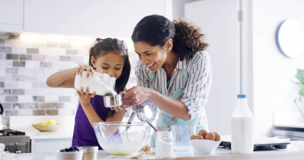 istock Help, mom and girl with kitchen, baking and learning with ingredients for pastry or dessert cake. Smile, happy mother and teaching cooking daughter for pudding, cookies or recipe prepare in home 2193668513