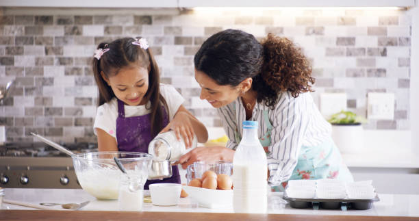 istock Help, mom and child with measure, baking and learning with ingredients for pastry or kitchen dessert. Smile, happy mother and teaching cooking daughter for pudding, cookies or recipe prepare in home 2193668672