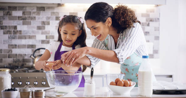 istock Help, mom and child with egg crack, baking and learning with ingredients for pastry or kitchen dessert. Bonding, happy mother and support daughter for teaching, cookies or recipe prepare in home 2193668675