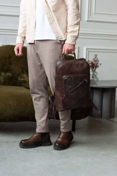 istock A Stylish and Professional Man Standing with a brown backpack in a Contemporary Modern Setting. 2193668852