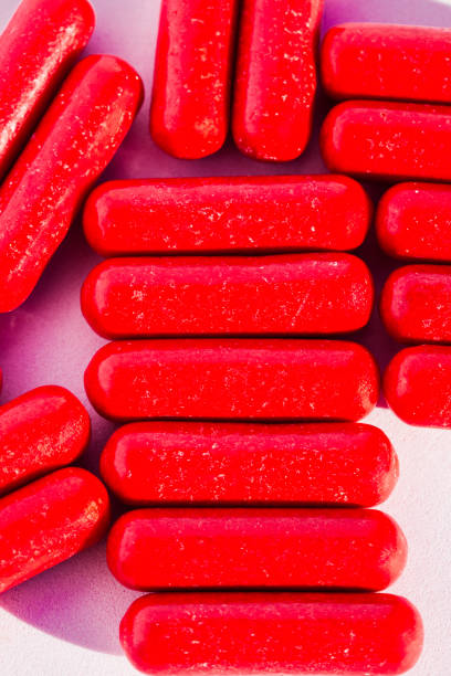 istock Vibrant red candy sticks on a pastel pink surface. 2193668897