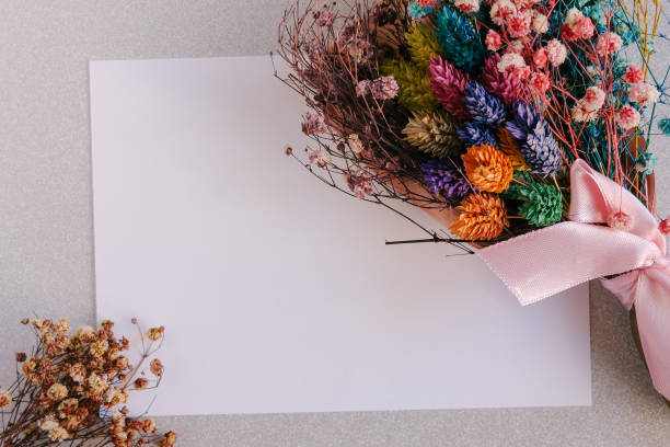 Blank greeting card with dried flowers on white glittery background. Wedding invitation. Mock up. Flat lay. Mothers day layout