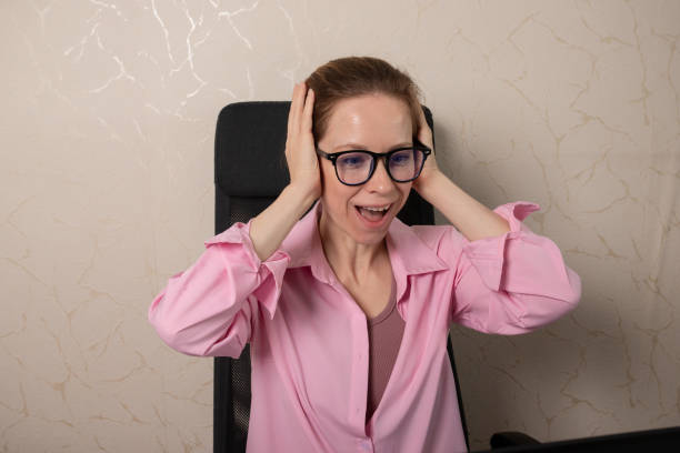 istock Surprised woman in office at laptop, working on a project, seated at a desk, using technology for remote work. 2193670308